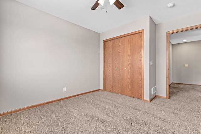 unfurnished bedroom featuring ceiling fan, carpet, a closet, and baseboards