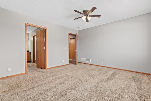 unfurnished bedroom featuring a ceiling fan, carpet, visible vents, baseboards, and a textured ceiling