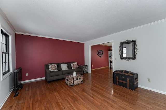 living room with ornamental molding, baseboards, and wood finished floors