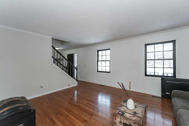 living area with stairway, visible vents, baseboards, wood-type flooring, and crown molding