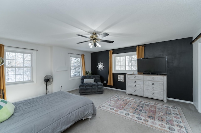 bedroom featuring baseboards, multiple windows, light colored carpet, and a ceiling fan