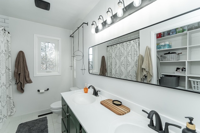 bathroom with double vanity, toilet, visible vents, and a sink