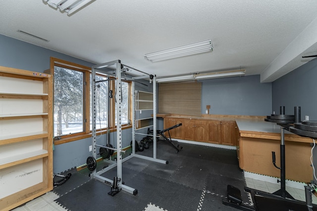 workout area featuring visible vents and a textured ceiling