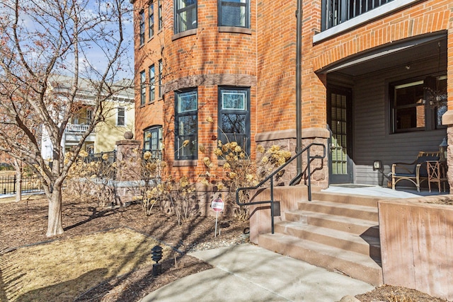 doorway to property with brick siding