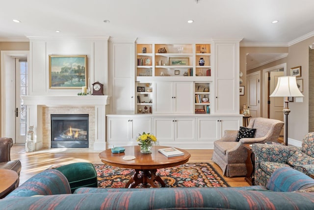 living area featuring light wood-style flooring, a fireplace with flush hearth, recessed lighting, and ornamental molding