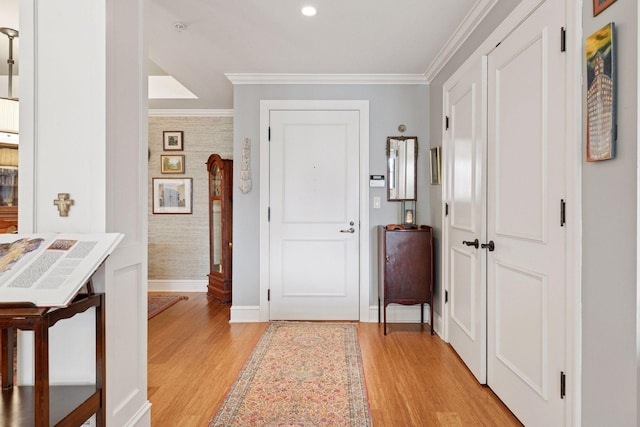 foyer entrance featuring baseboards, light wood finished floors, wallpapered walls, recessed lighting, and ornamental molding