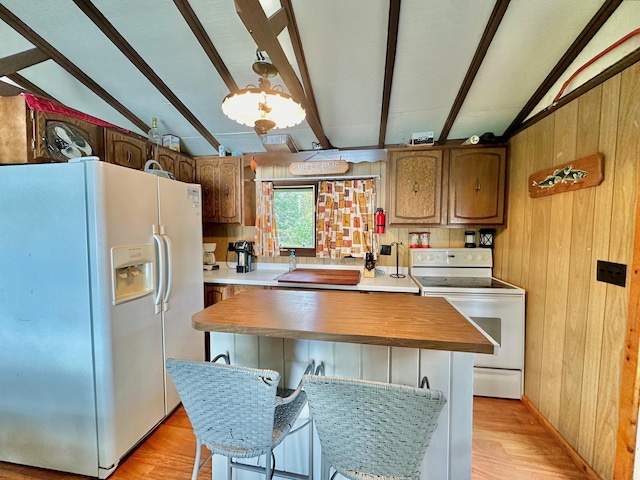 kitchen with lofted ceiling with beams, white appliances, and wood walls