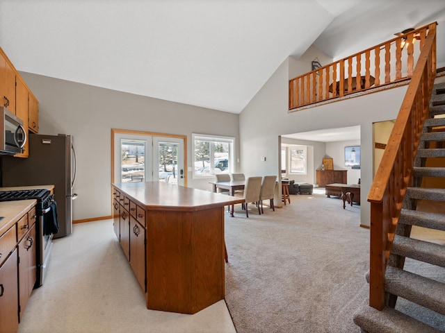 17170 Highview Ave, Minnewaska Twp, MN 56334 - kitchen with range with gas cooktop, stainless steel microwave, high vaulted ceiling, light carpet, and a center island