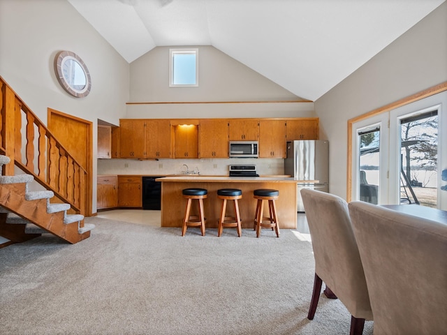 17170 Highview Ave, Minnewaska Twp, MN 56334 - kitchen featuring appliances with stainless steel finishes, high vaulted ceiling, light countertops, brown cabinetry, and light carpet
