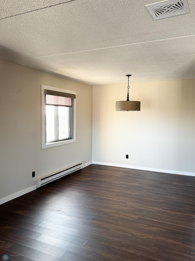 1110 3rd Ave N Unit 704E, Fargo, ND 58102 - empty room with a textured ceiling, a baseboard heating unit, baseboards, dark wood-style flooring, and visible vents