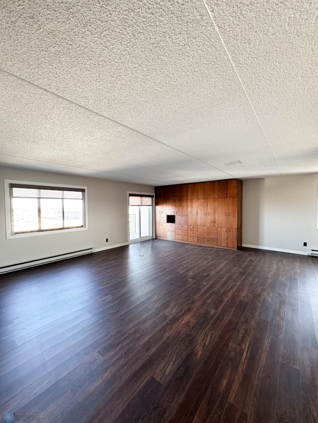 1110 3rd Ave N Unit 704E, Fargo, ND 58102 - unfurnished living room featuring a baseboard heating unit, baseboards, dark wood-style floors, and a textured ceiling