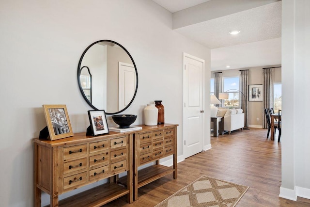 corridor with baseboards, wood finished floors, and recessed lighting