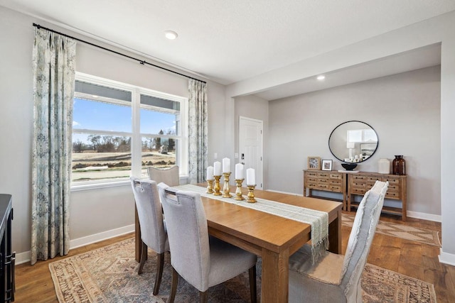 dining space featuring baseboards, wood finished floors, and recessed lighting