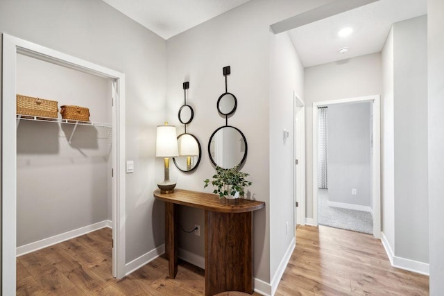 hallway featuring wood finished floors and baseboards