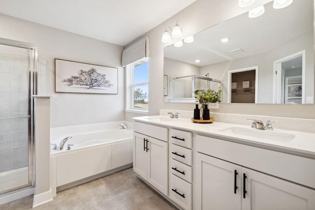 bathroom with double vanity, a stall shower, a garden tub, and a sink