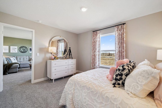 carpeted bedroom featuring a textured ceiling and baseboards