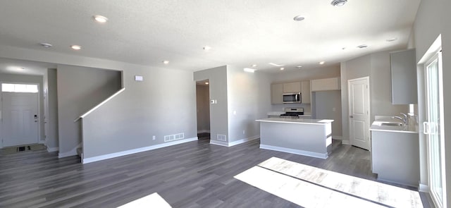 kitchen with visible vents, a center island, baseboards, light countertops, and appliances with stainless steel finishes