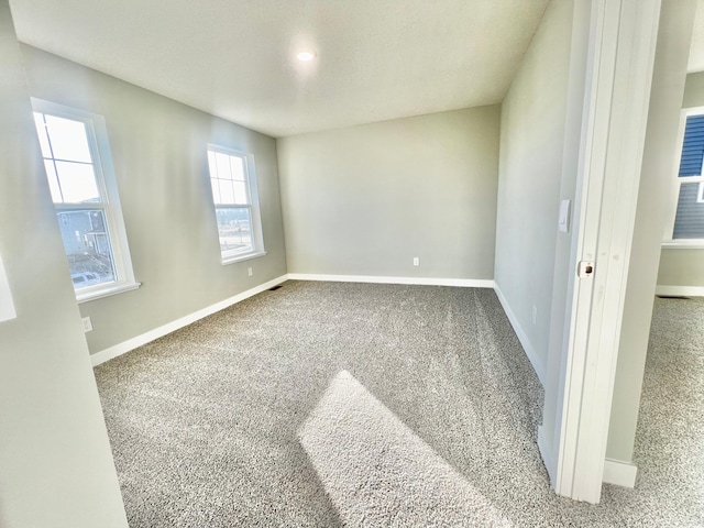 carpeted empty room with baseboards