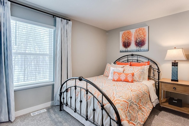 carpeted bedroom with visible vents and baseboards