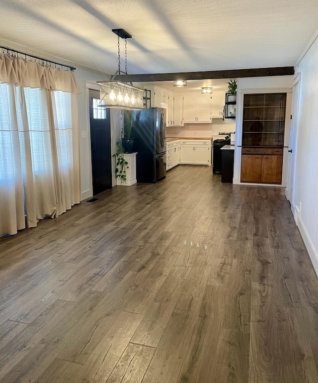 interior space featuring a textured ceiling, dark wood finished floors, visible vents, and baseboards