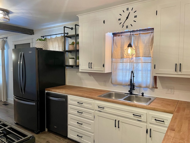 kitchen with black appliances, butcher block counters, white cabinets, and a sink