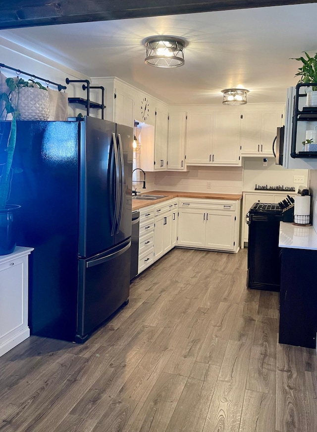 kitchen featuring dark wood-style floors, freestanding refrigerator, white cabinetry, and dishwashing machine