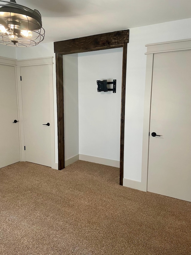 spare room with carpet flooring and a notable chandelier