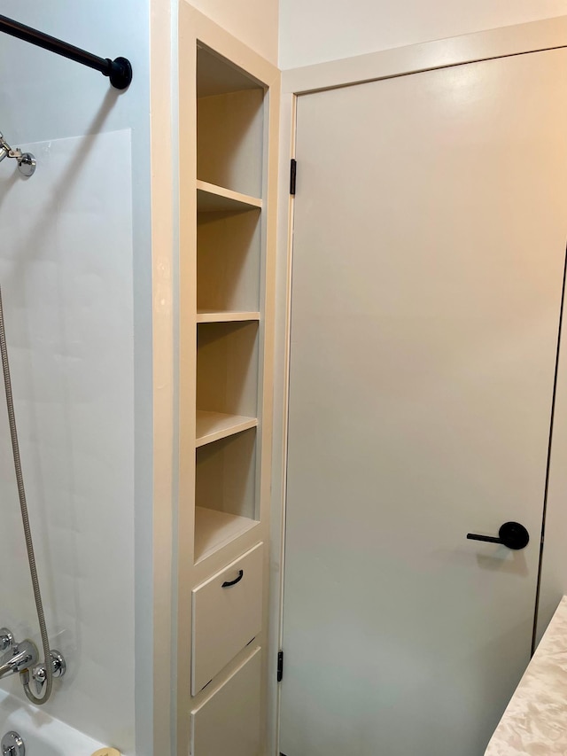 bathroom featuring built in features and shower / bathing tub combination