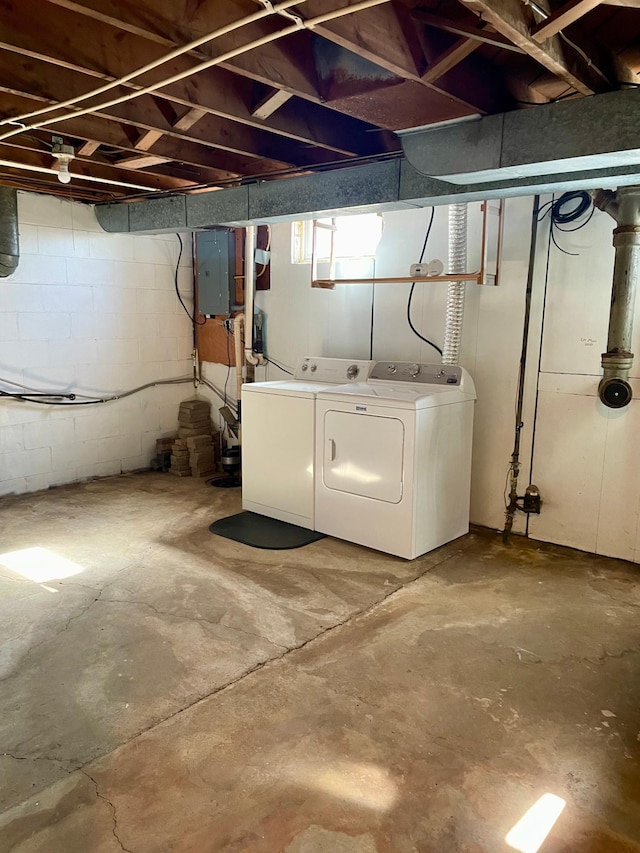 basement with washing machine and clothes dryer and electric panel