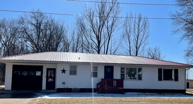 ranch-style house featuring metal roof and a garage