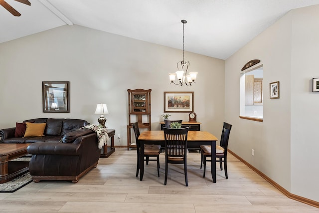 dining space featuring lofted ceiling with beams, ceiling fan with notable chandelier, light wood-type flooring, and baseboards