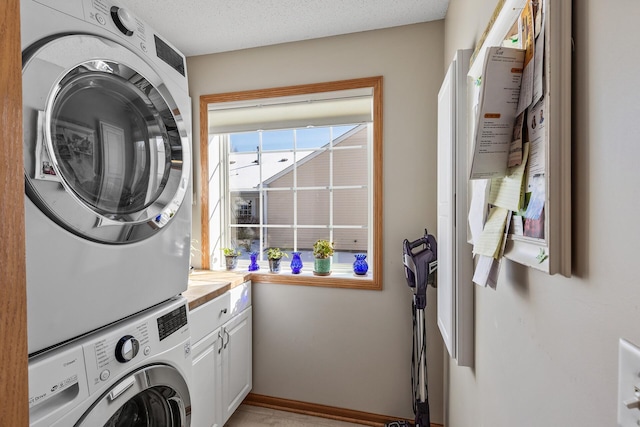 laundry room with cabinet space, stacked washer / drying machine, and a textured ceiling