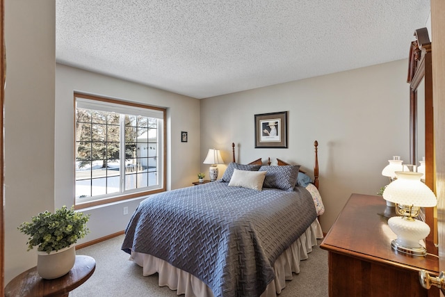 carpeted bedroom featuring a textured ceiling and baseboards