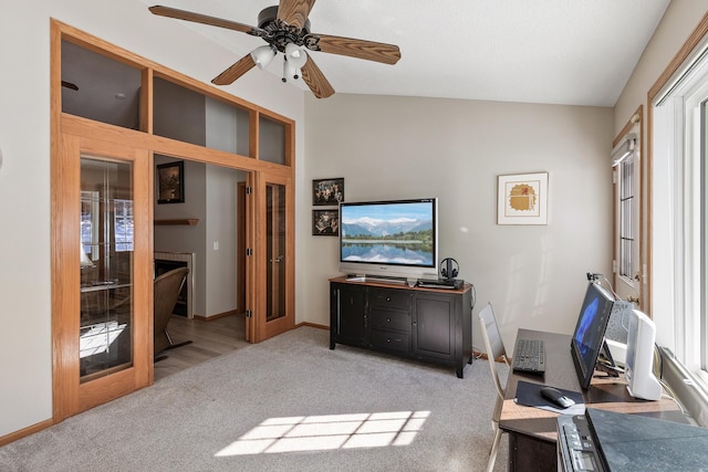 interior space with baseboards, carpet floors, ceiling fan, and vaulted ceiling