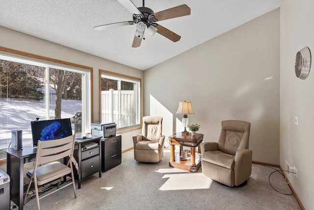 carpeted home office featuring a textured ceiling, lofted ceiling, baseboards, and a ceiling fan