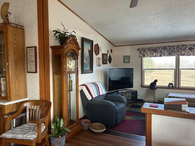 living area featuring a textured ceiling, wood finished floors, ornamental molding, and wallpapered walls