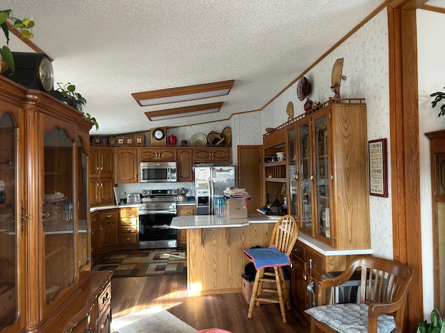 kitchen with stainless steel appliances, ornamental molding, light countertops, and wallpapered walls