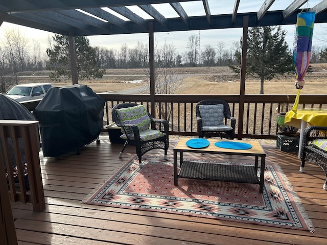 wooden terrace with an outdoor hangout area, a rural view, and a grill