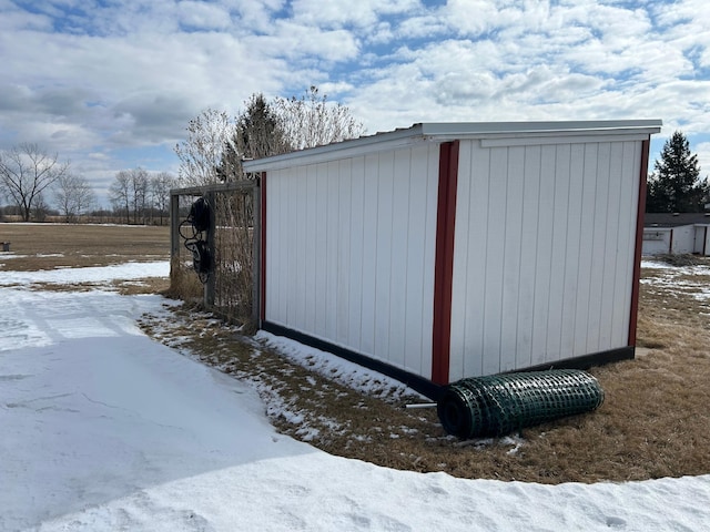 snow covered structure with an outbuilding