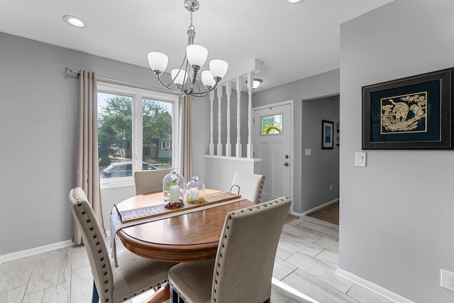 607 Adams St NE, Minneapolis, MN 55413 - dining space featuring a chandelier, baseboards, and a textured ceiling