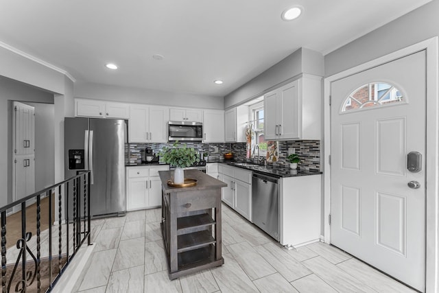 607 Adams St NE, Minneapolis, MN 55413 - kitchen with stainless steel appliances, dark countertops, a sink, tasteful backsplash, and white cabinetry