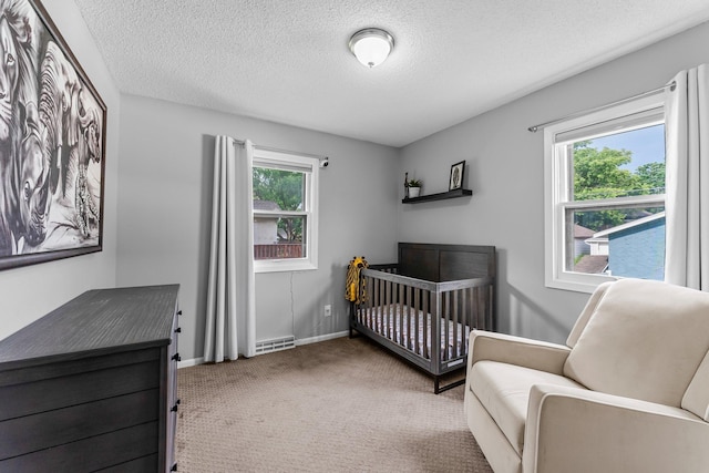 607 Adams St NE, Minneapolis, MN 55413 - carpeted bedroom with a textured ceiling, a crib, and baseboards
