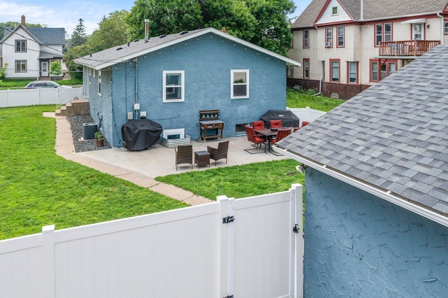 607 Adams St NE, Minneapolis, MN 55413 - back of house with a gate, stucco siding, a patio area, central air condition unit, and a shingled roof