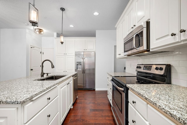 kitchen featuring tasteful backsplash, appliances with stainless steel finishes, dark wood-style floors, white cabinetry, and a sink