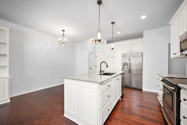 kitchen featuring dark wood finished floors, baseboards, appliances with stainless steel finishes, and a sink