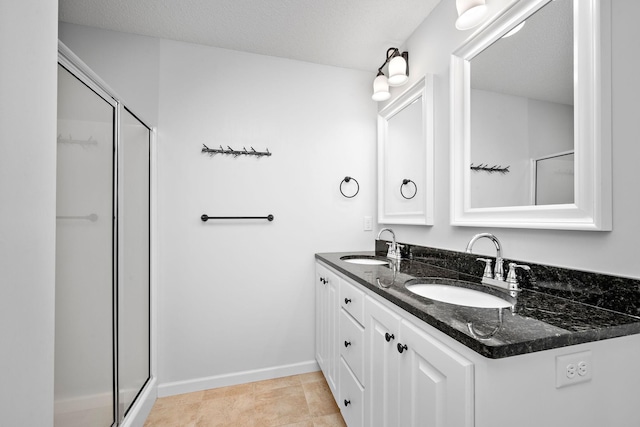 bathroom with double vanity, a stall shower, and a sink