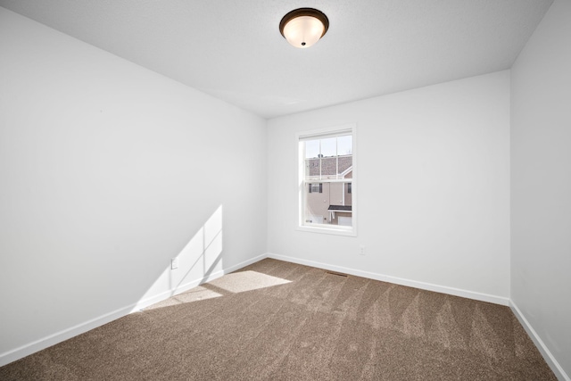 spare room featuring baseboards and carpet floors