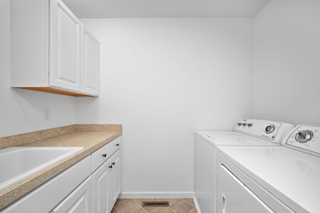 laundry room featuring visible vents, independent washer and dryer, a sink, cabinet space, and baseboards