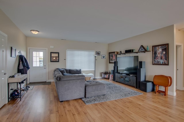 living room featuring visible vents, light wood-style flooring, and baseboards