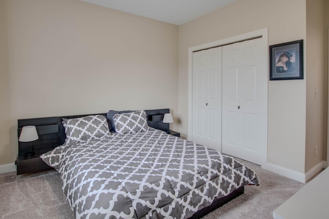 carpeted bedroom with a closet and baseboards